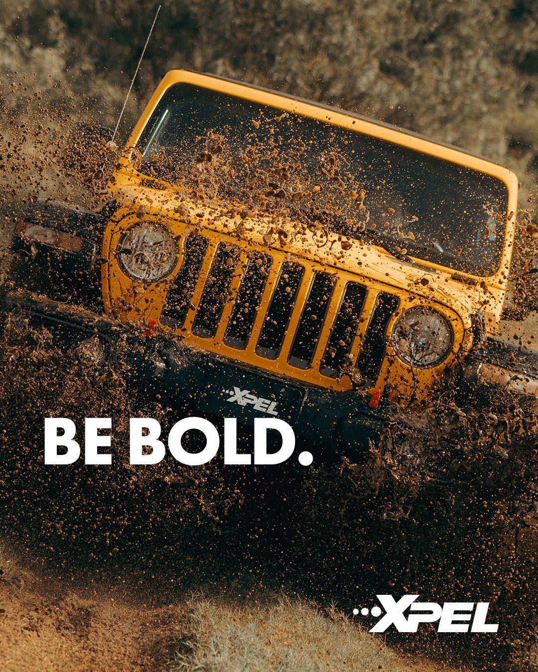 Yellow Jeep splashes through mud 