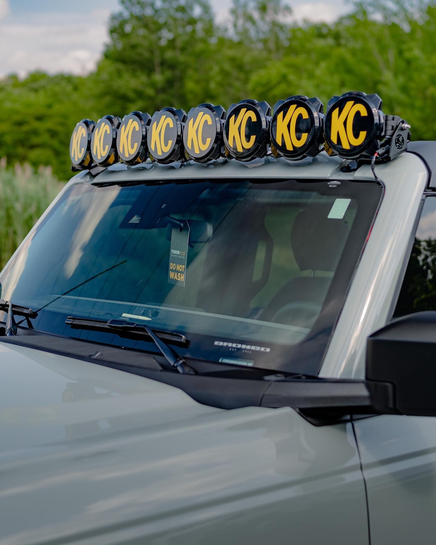 A man is applying tinted window film to a black car.