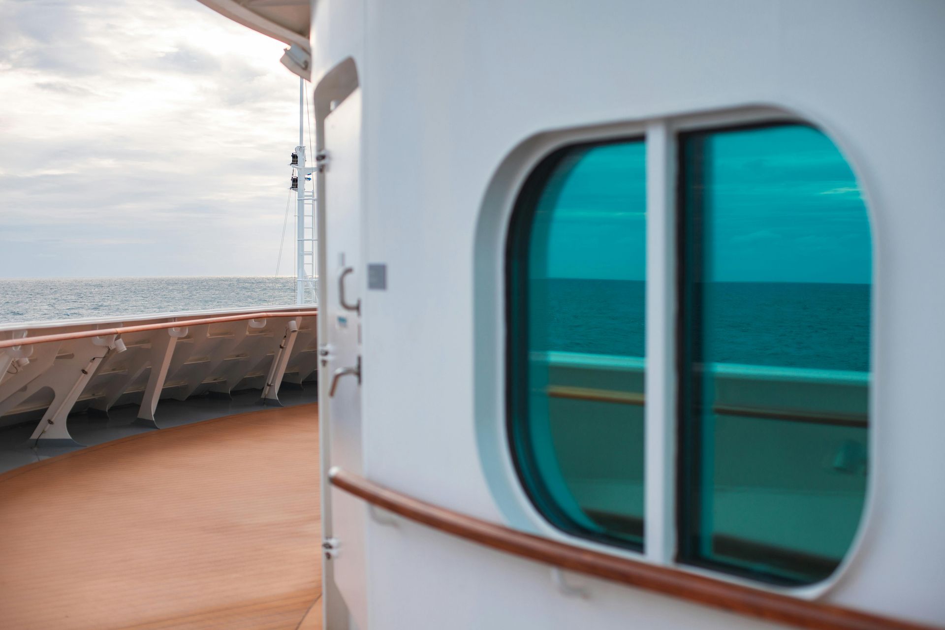 A close up of a window on a cruise ship looking out over the ocean.