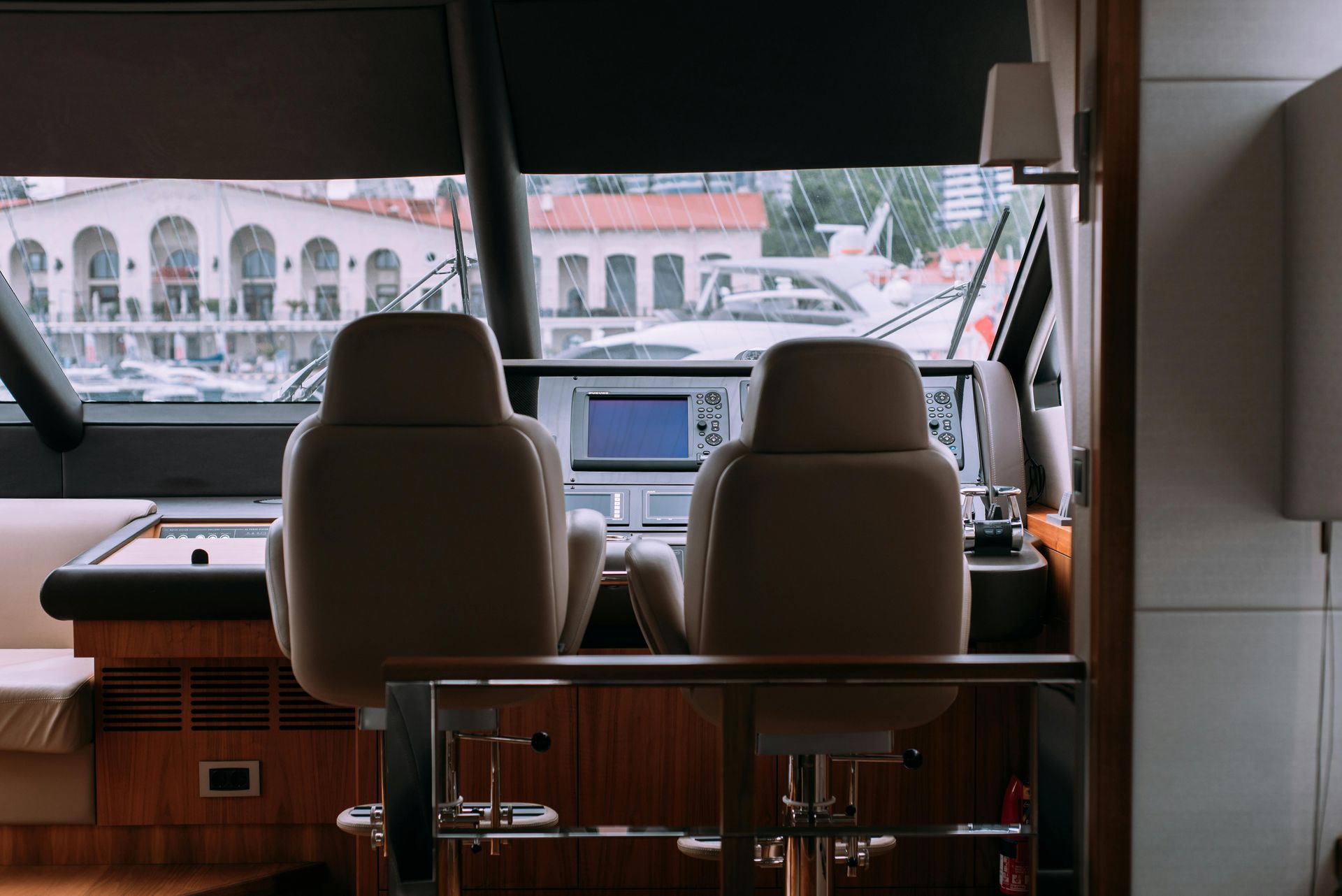 There are two chairs in the cockpit of a boat.