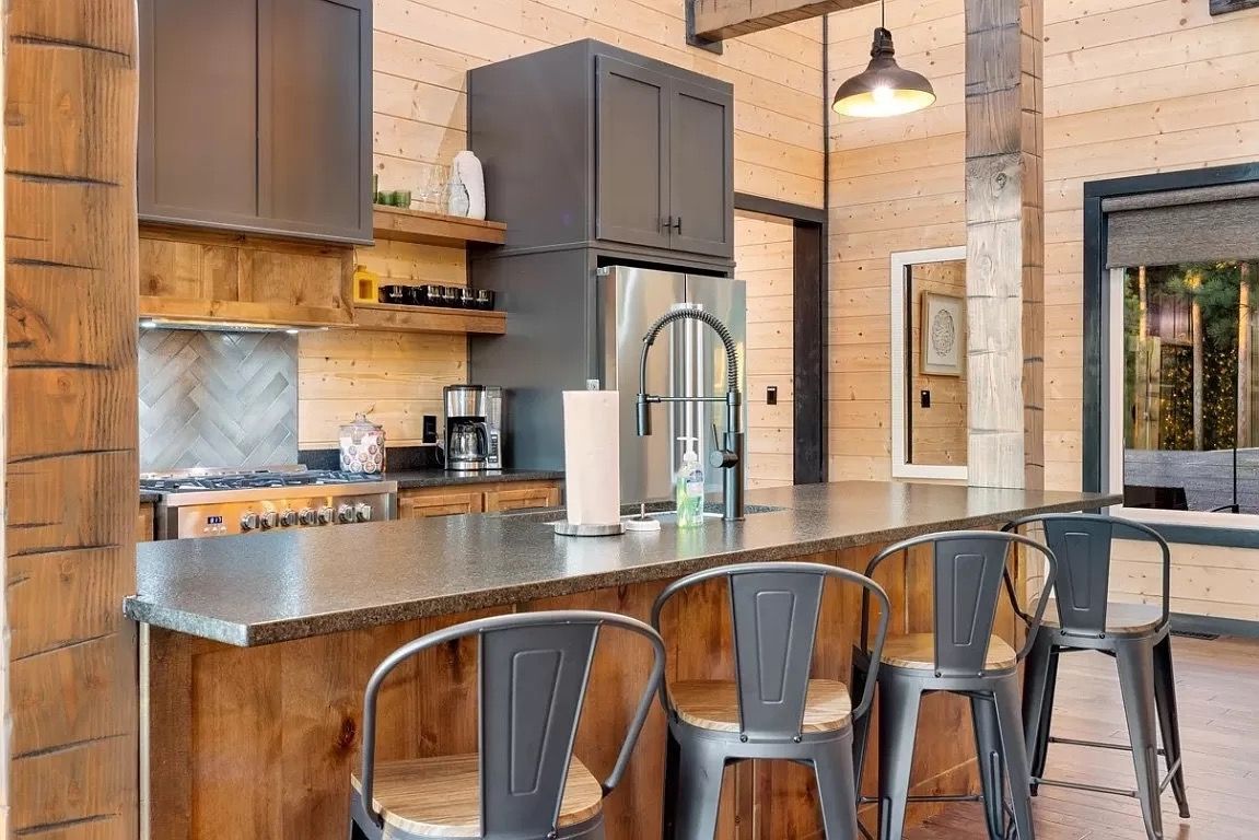 A kitchen with a stainless steel counter top and wooden cabinets.