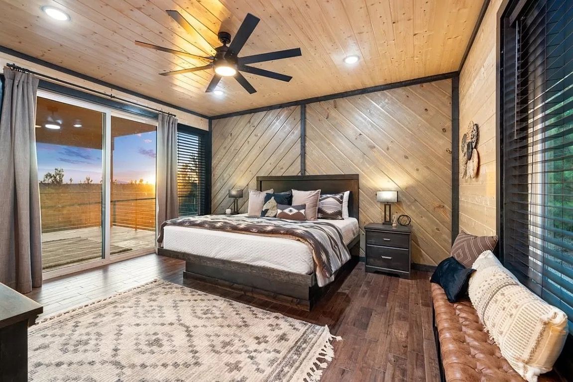 A bedroom with a king size bed and a ceiling fan.