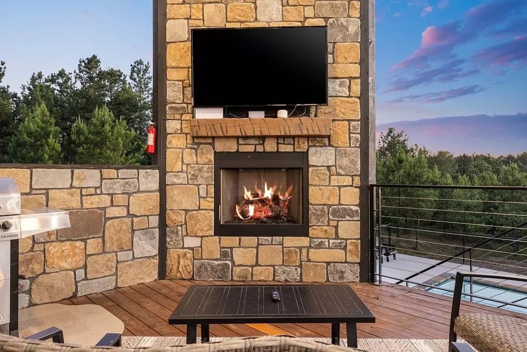 A stone fireplace with a flat screen tv mounted above it.