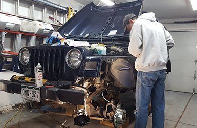 Jeep Upgrades — Man Repairing the Jeep Engine in Aurora, CO