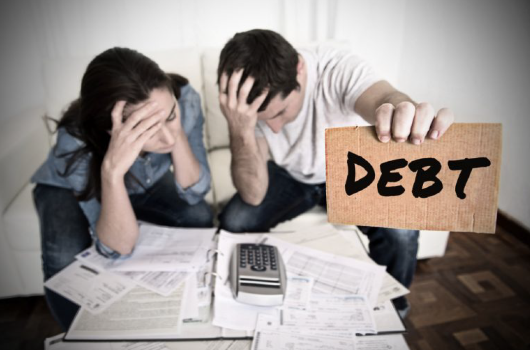 Two People Holding a Sign That Says Debt — Florissant, MO — Teague & Associates, LLC