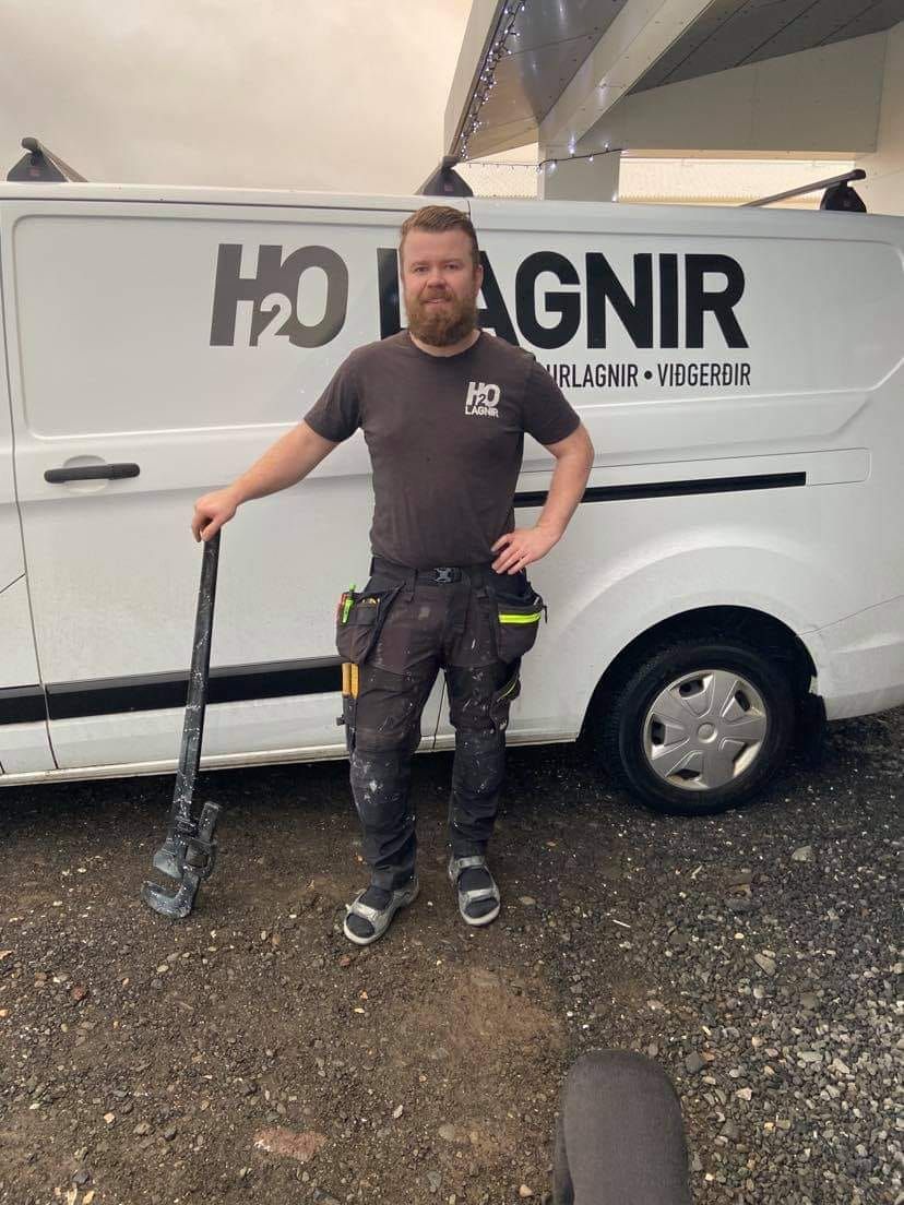 A man is standing in front of a white van that says h2o lagnir.