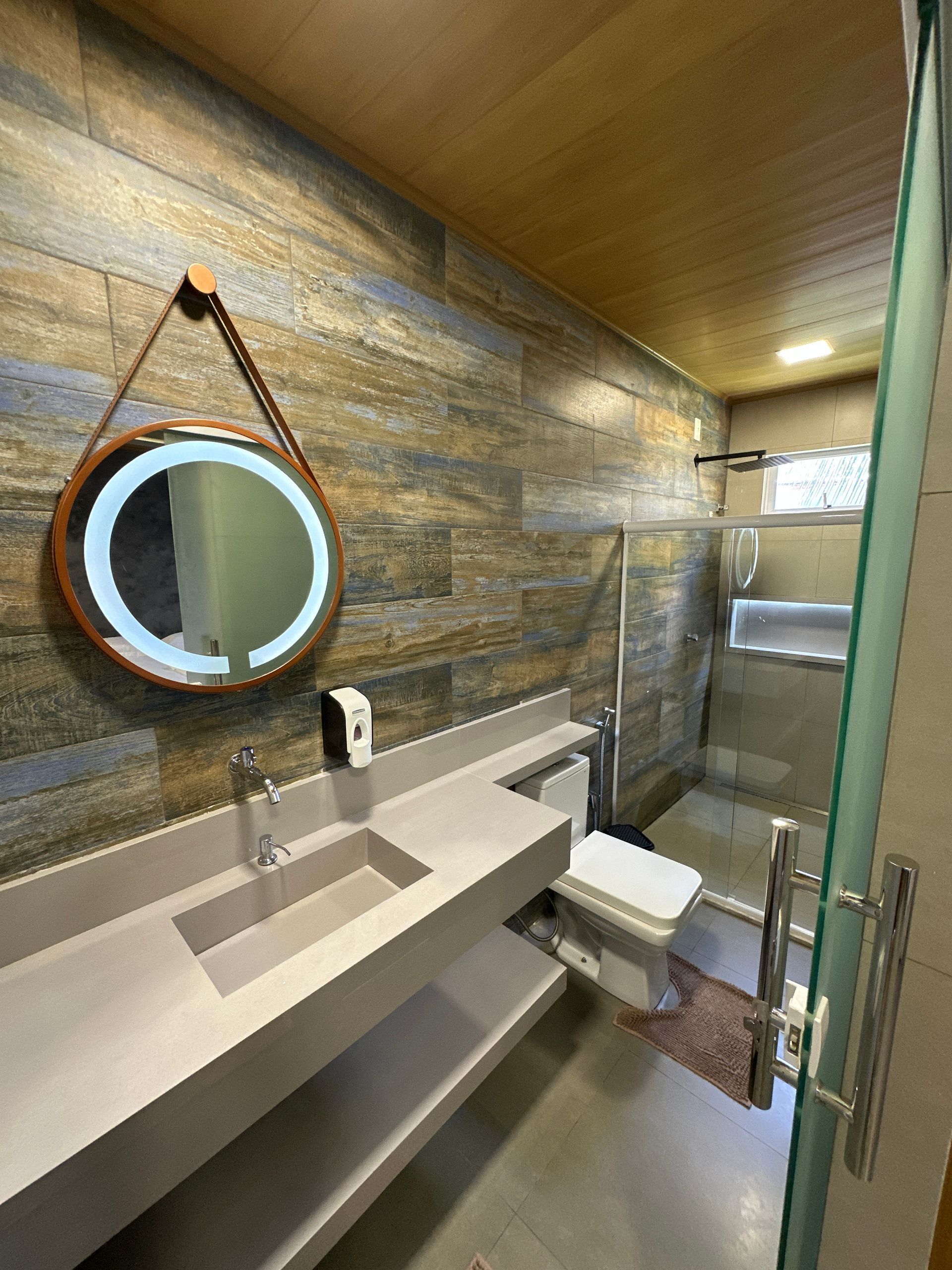 Um banheiro com pia, vaso sanitário e espelho.