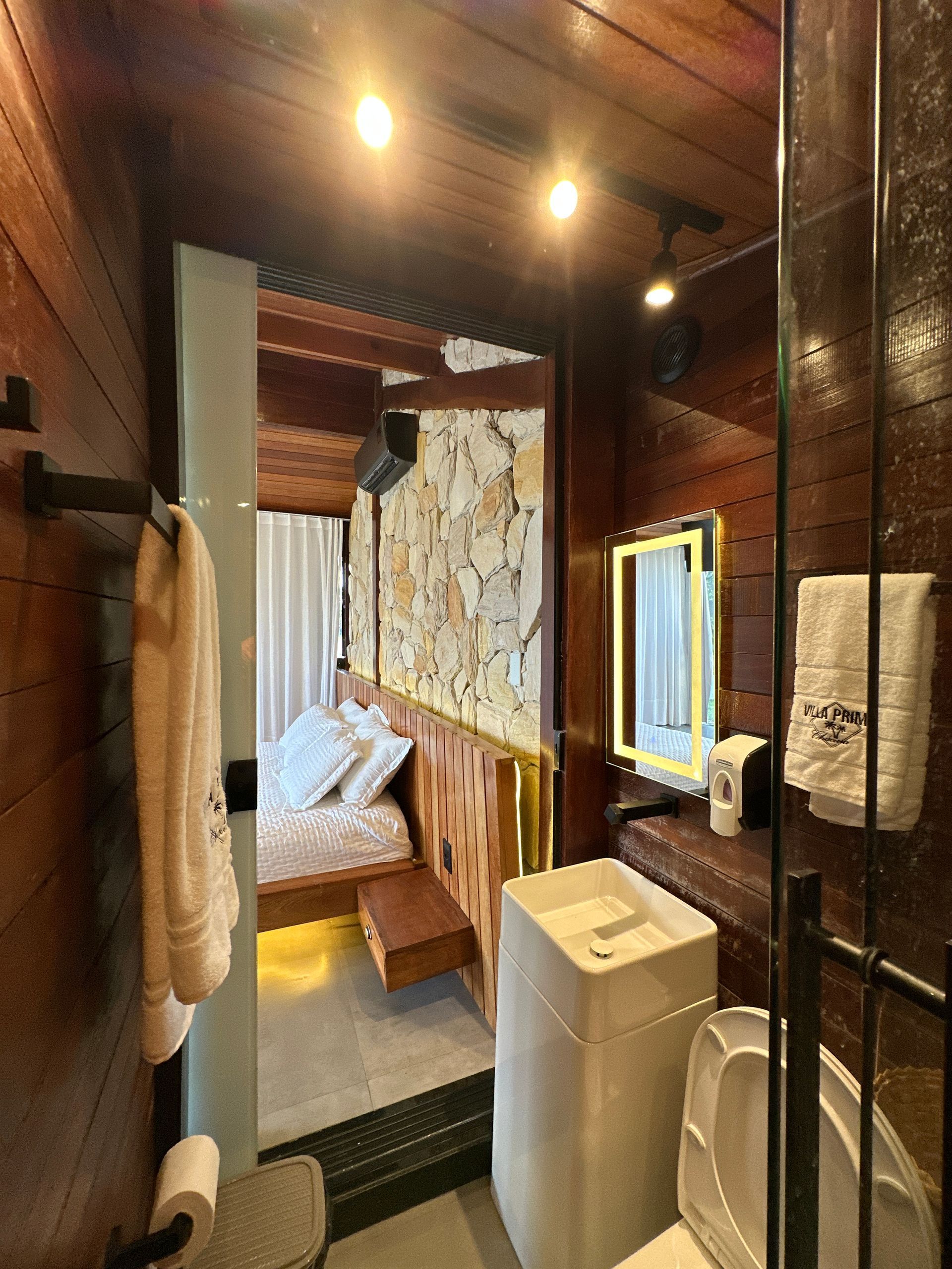 Um banheiro com vaso sanitário, pia e espelho.