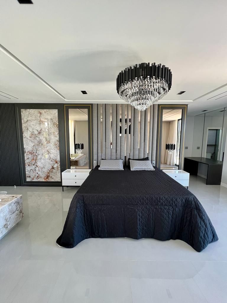 Um quarto com uma cama grande e um lustre pendurado no teto.