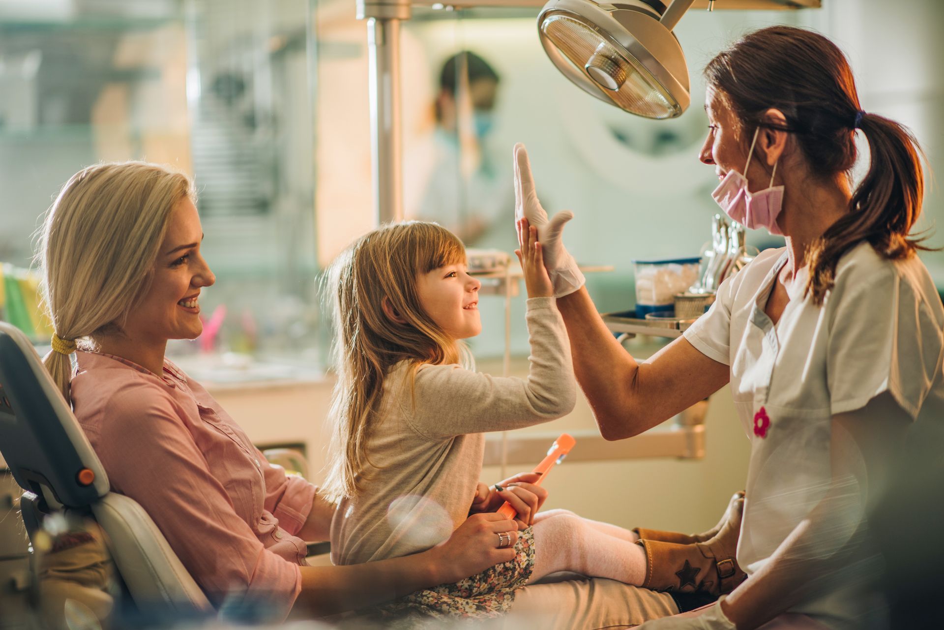 A woman and a little girl comfortably seated in a dentist chair at a pediatric dentist in Kodiak, AK