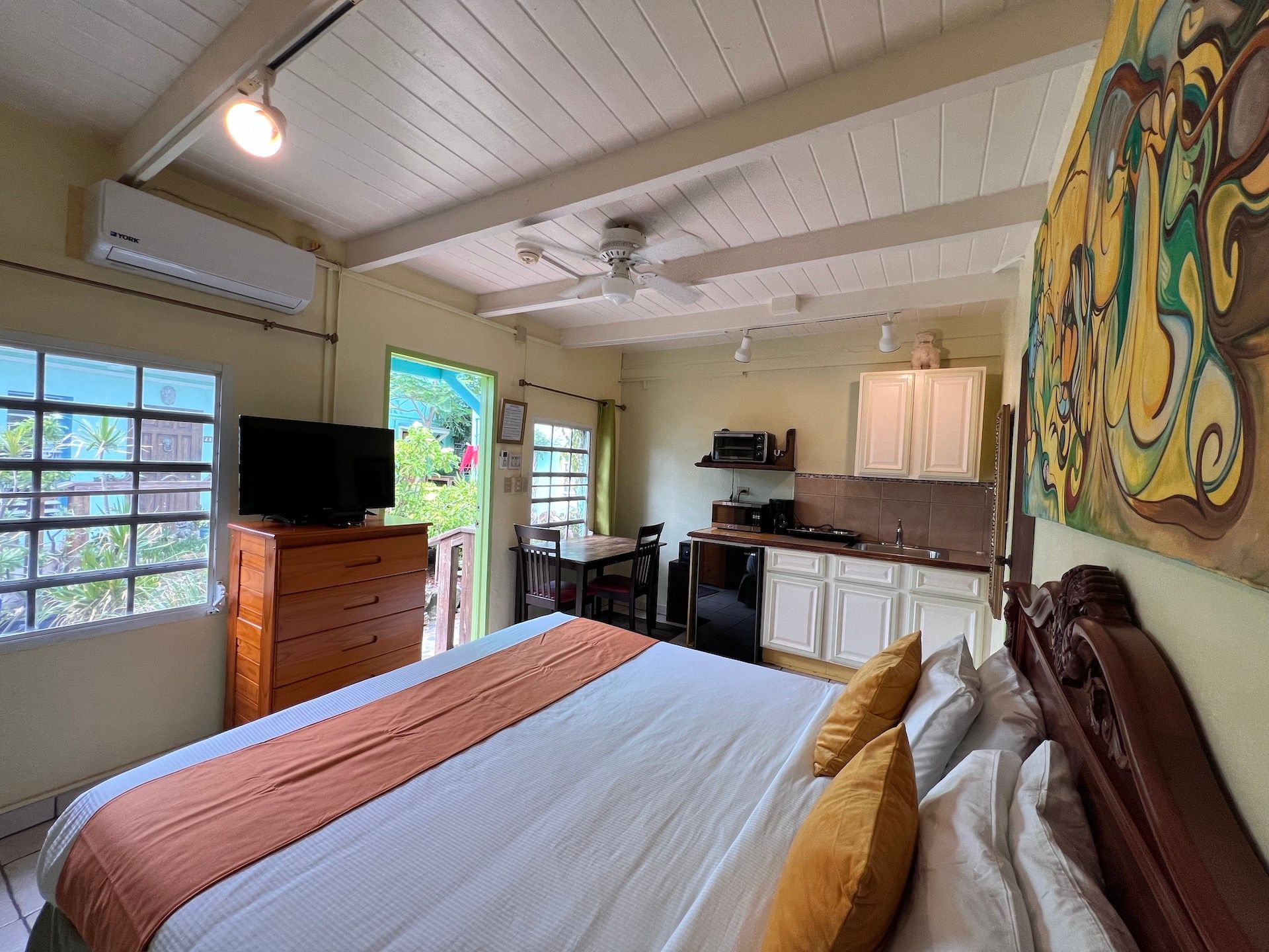 Bedroom studio with bed, kitchenette, and outdoor access.