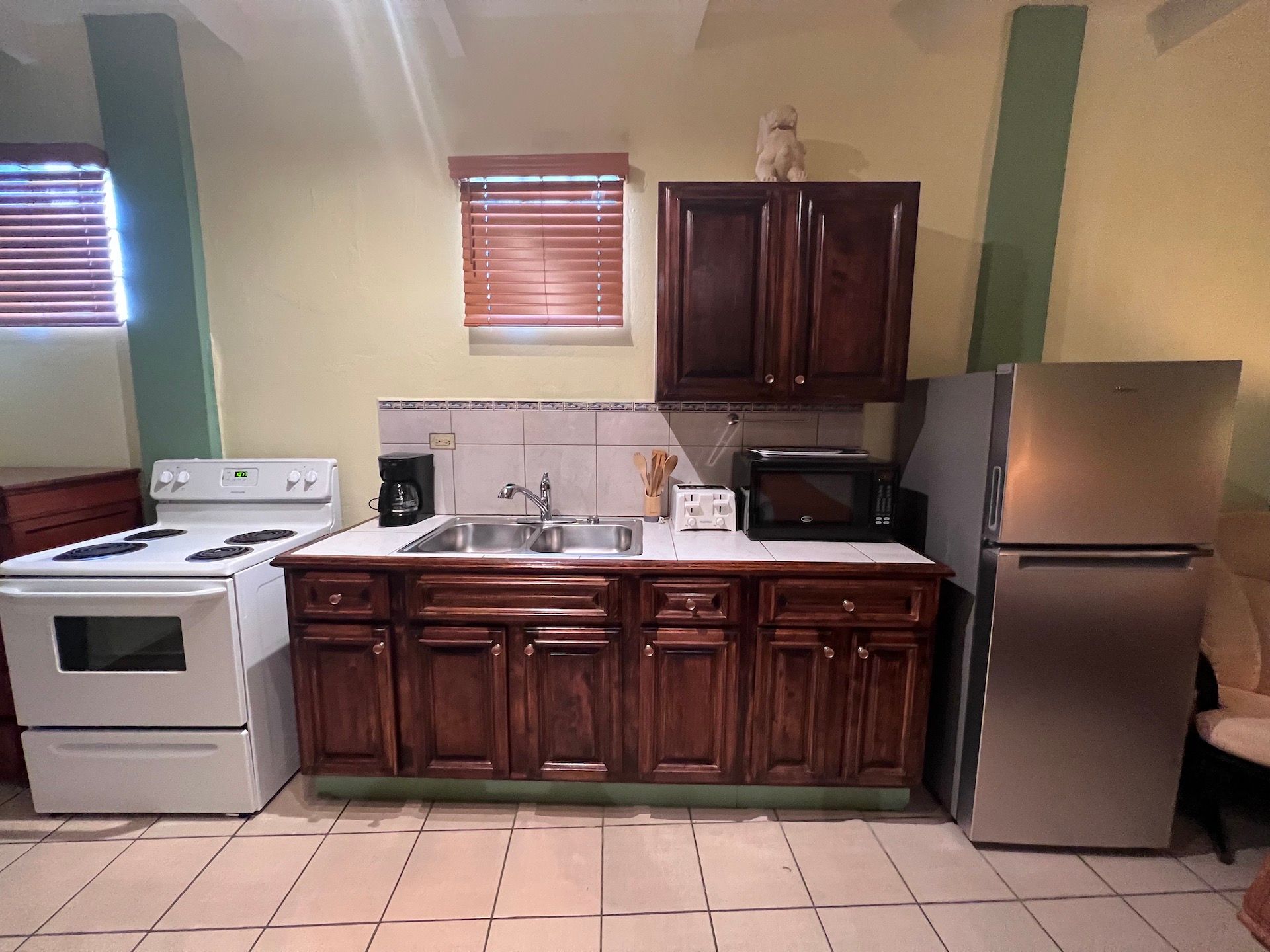 Kitchen with white appliances, dark wood cabinets, and a stainless steel refrigerator.