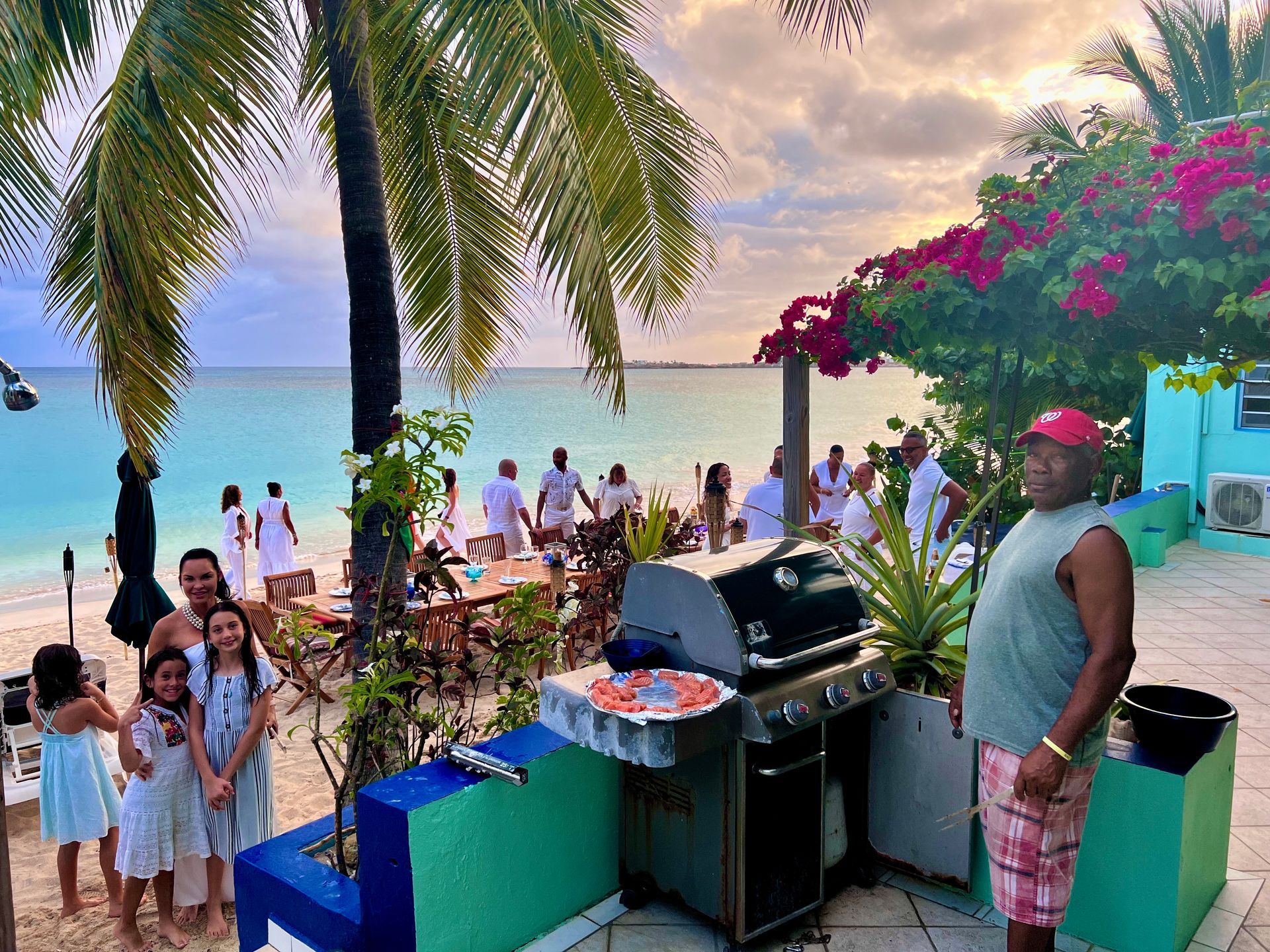 Beachfront BBQ. Family near grill, party on the beach, palm trees, ocean view.