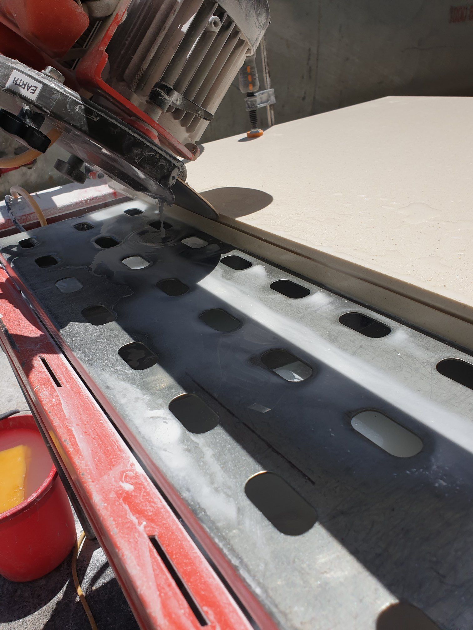 A Wet Tile Saw Cutting a Light-coloured Tile — Tropic Tiling in Tolga, QLD