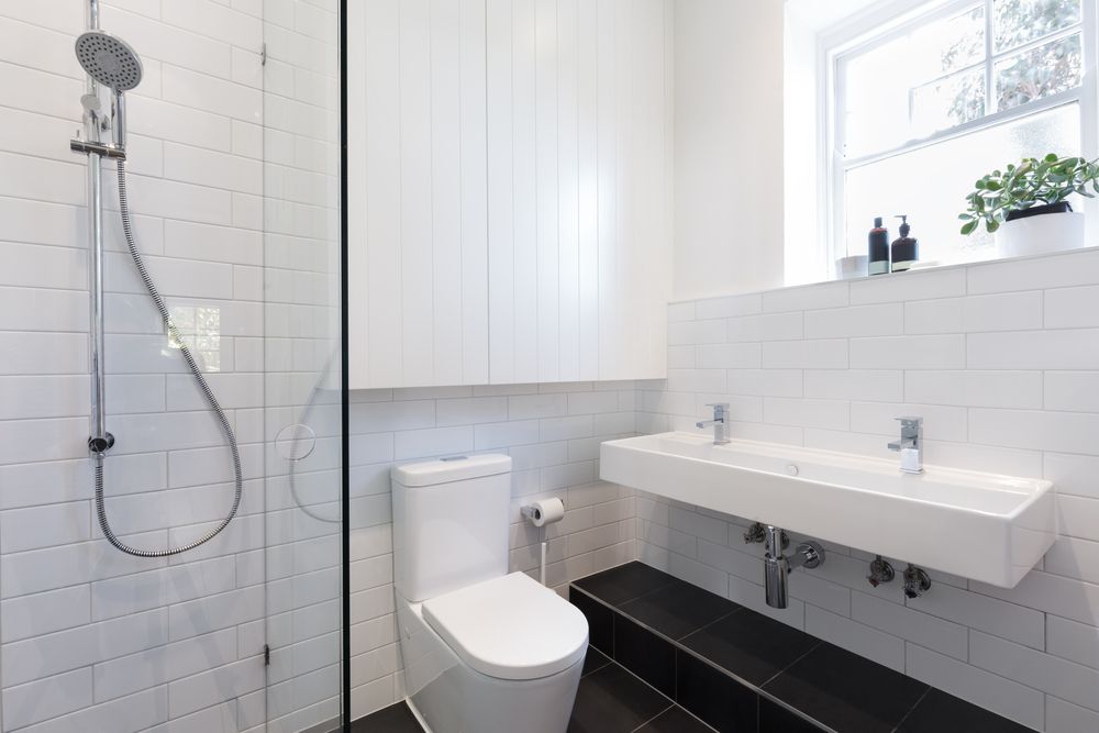 White Bathroom With Shower, Toilet, Sink, and White Tiles — Tropic Tiling in Tolga, QLD