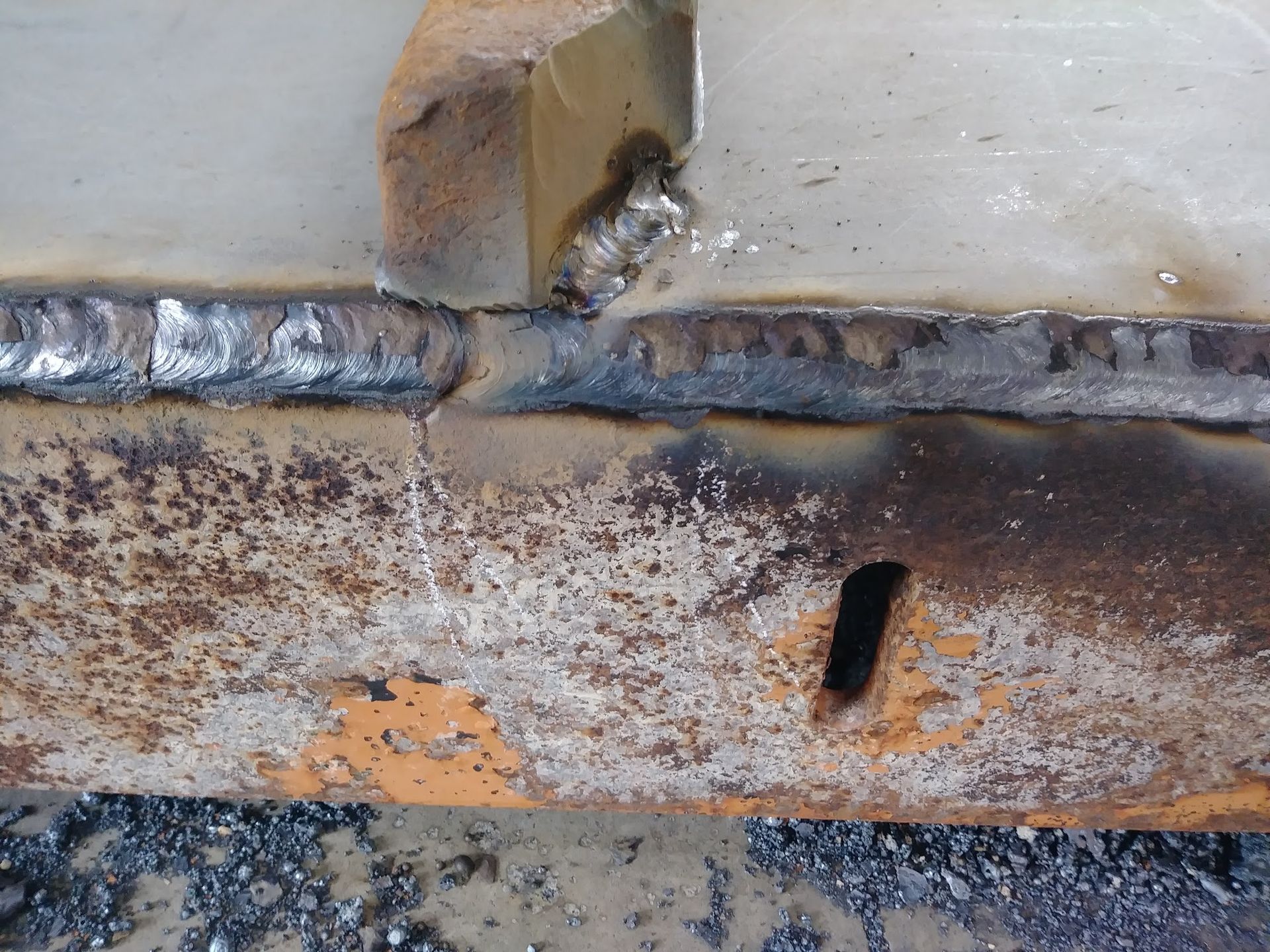 A piece of rusty metal with a hole in it