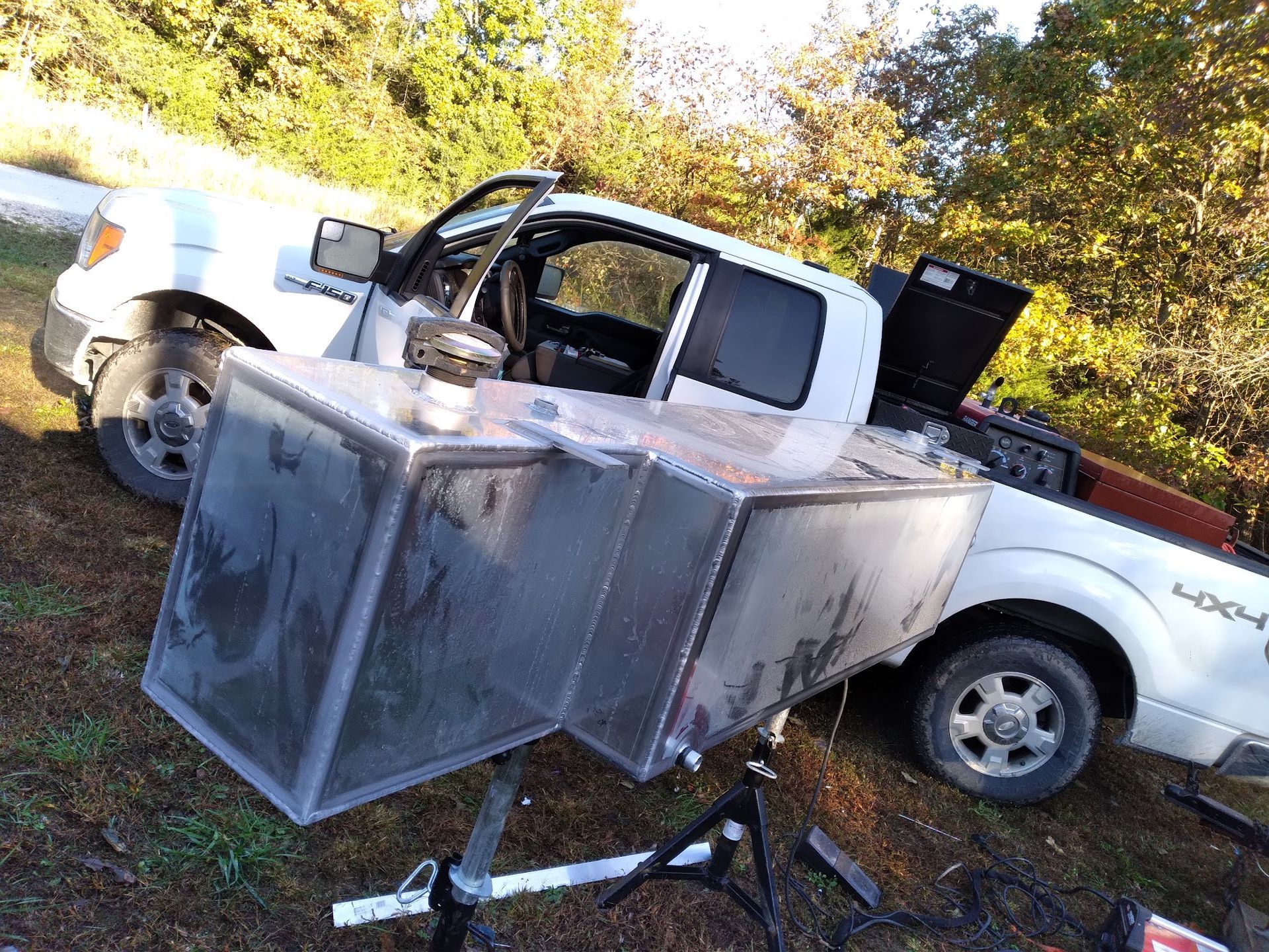 A white truck is parked in a field with boxes in the back.