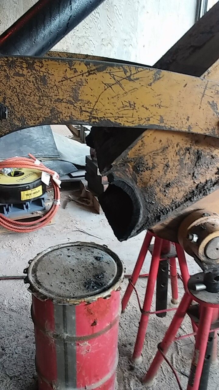 A red barrel is sitting next to a piece of equipment.