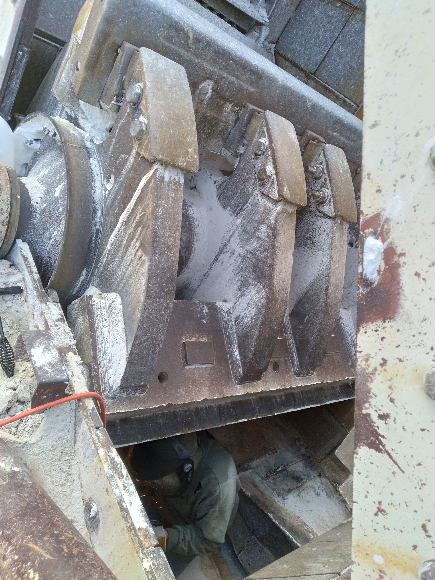 A person is working on a machine with a red wire coming out of it.