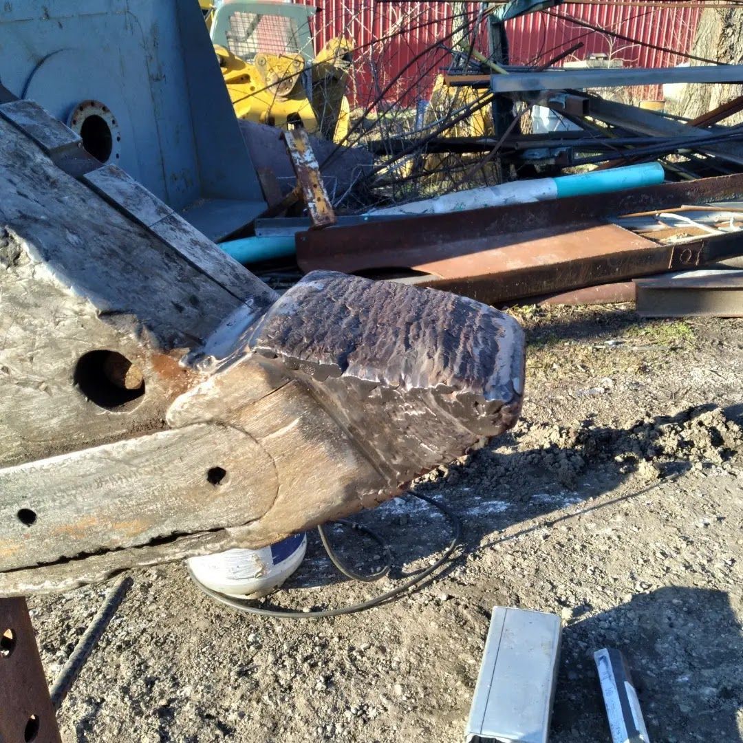 A piece of wood is sitting on top of a pile of metal.