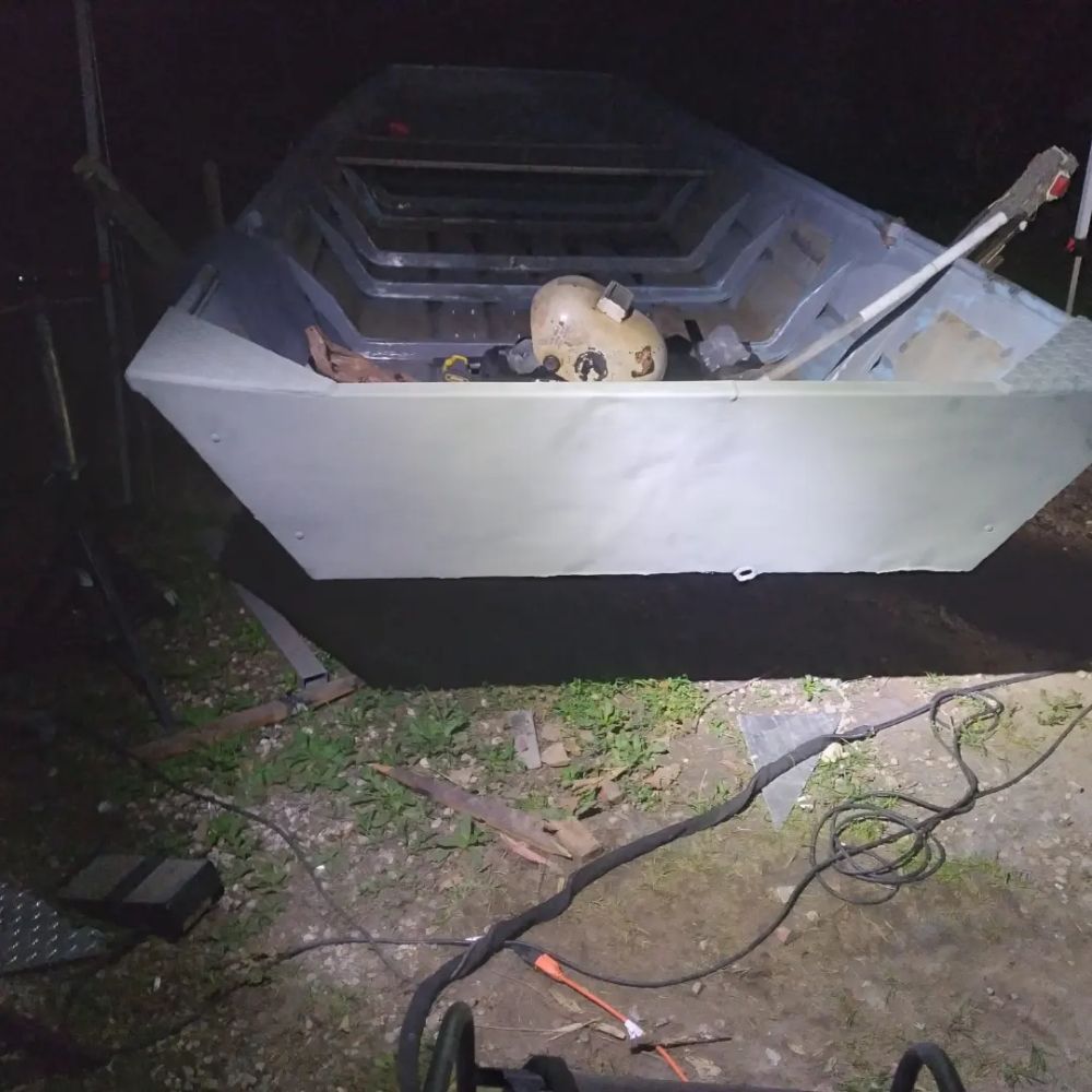 A boat is sitting on the ground with a helmet in it