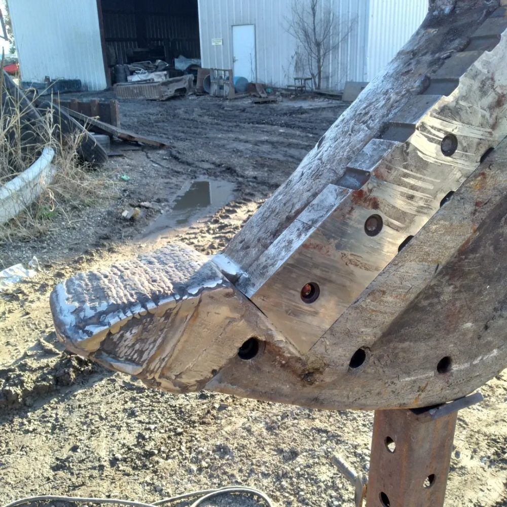 A piece of wood with holes in it is sitting in the dirt