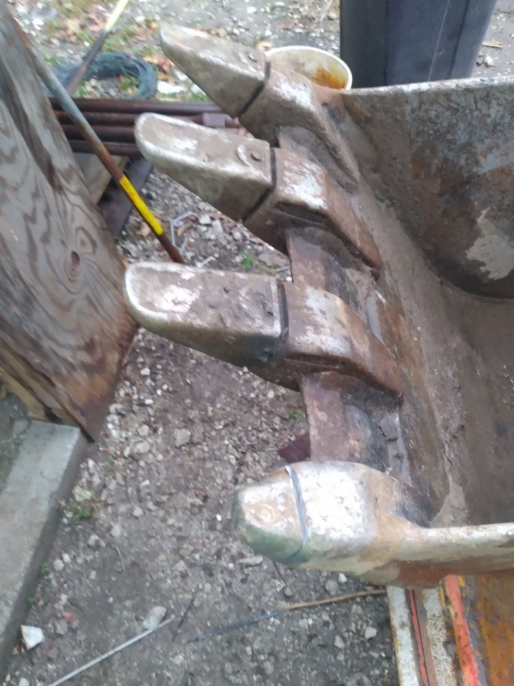 A close up of a shovel 's claw on the ground.