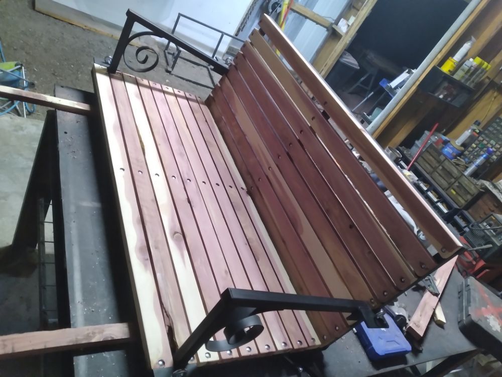 A wooden bench with a metal frame sits in a room