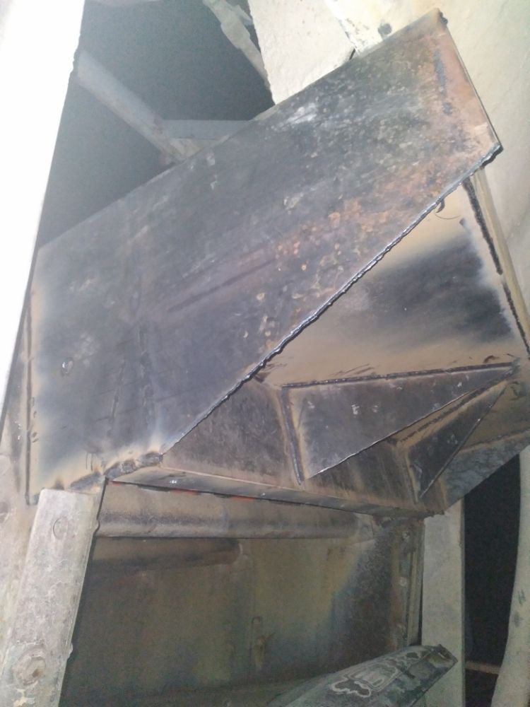 A piece of metal is sitting on top of a wooden table.