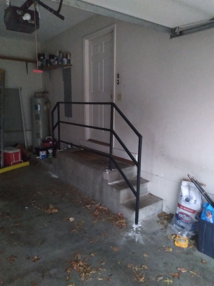 A garage with stairs and a black railing