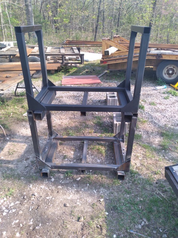 A metal frame is sitting on top of a dirt field.