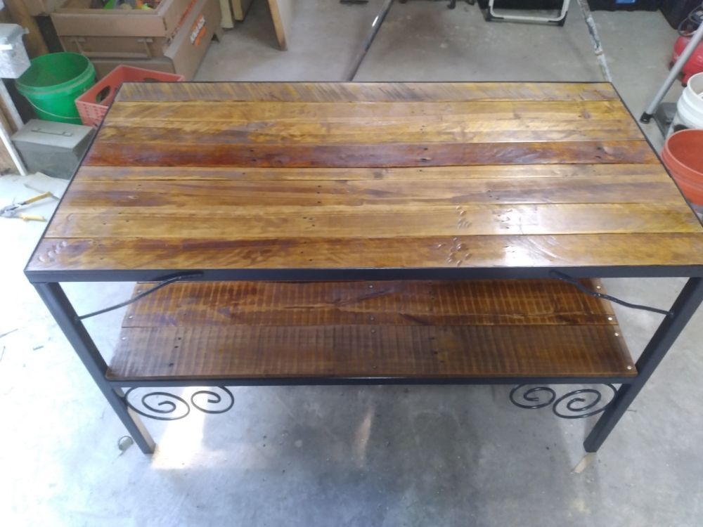 A wooden table with a metal frame and a shelf underneath it