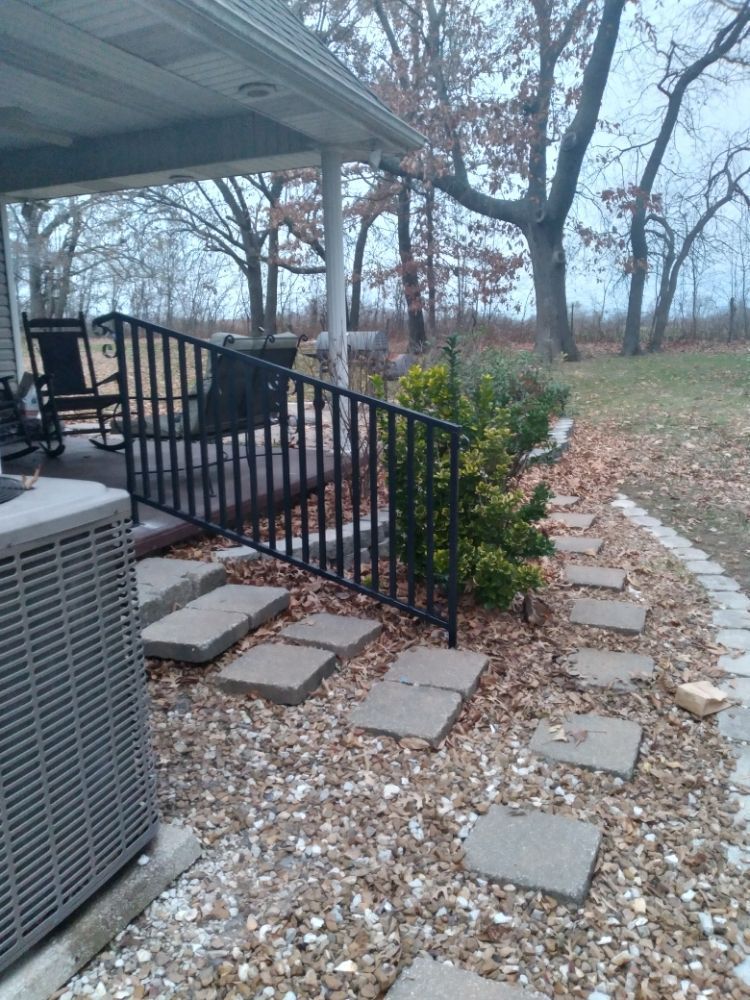 A patio with a fence and a walkway leading to it.