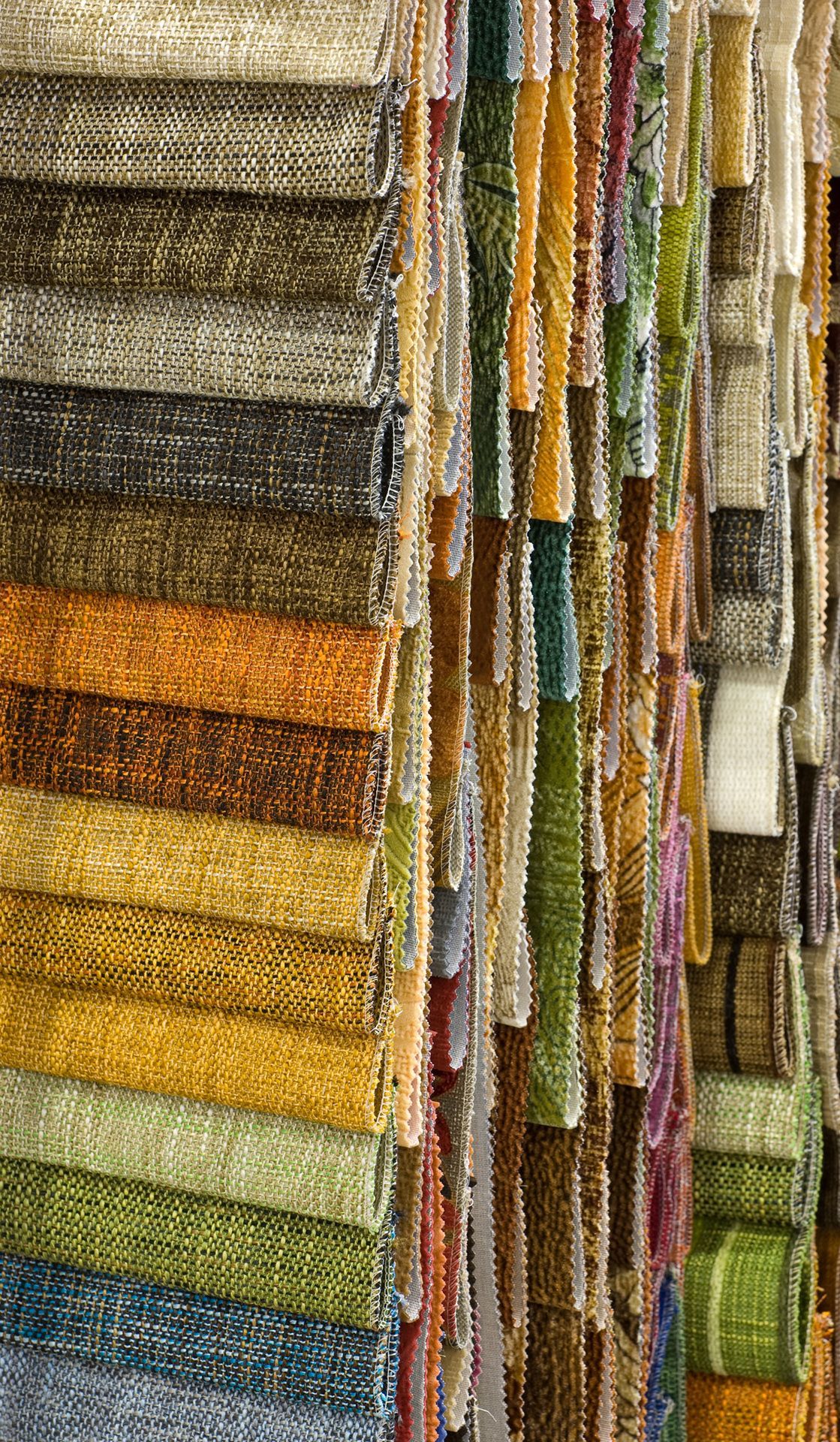 Una pila de telas coloridas colgadas en un estante en una tienda.