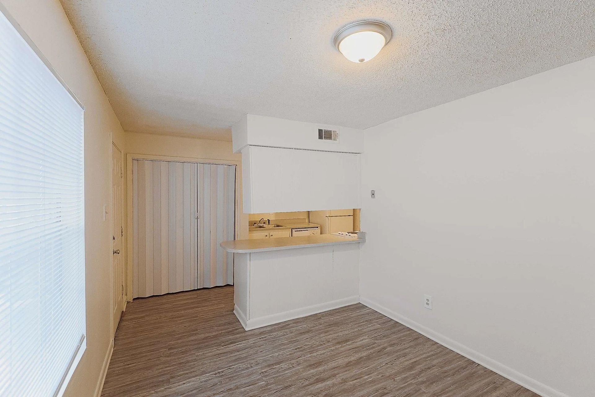 An empty room with a sliding glass door and a window.