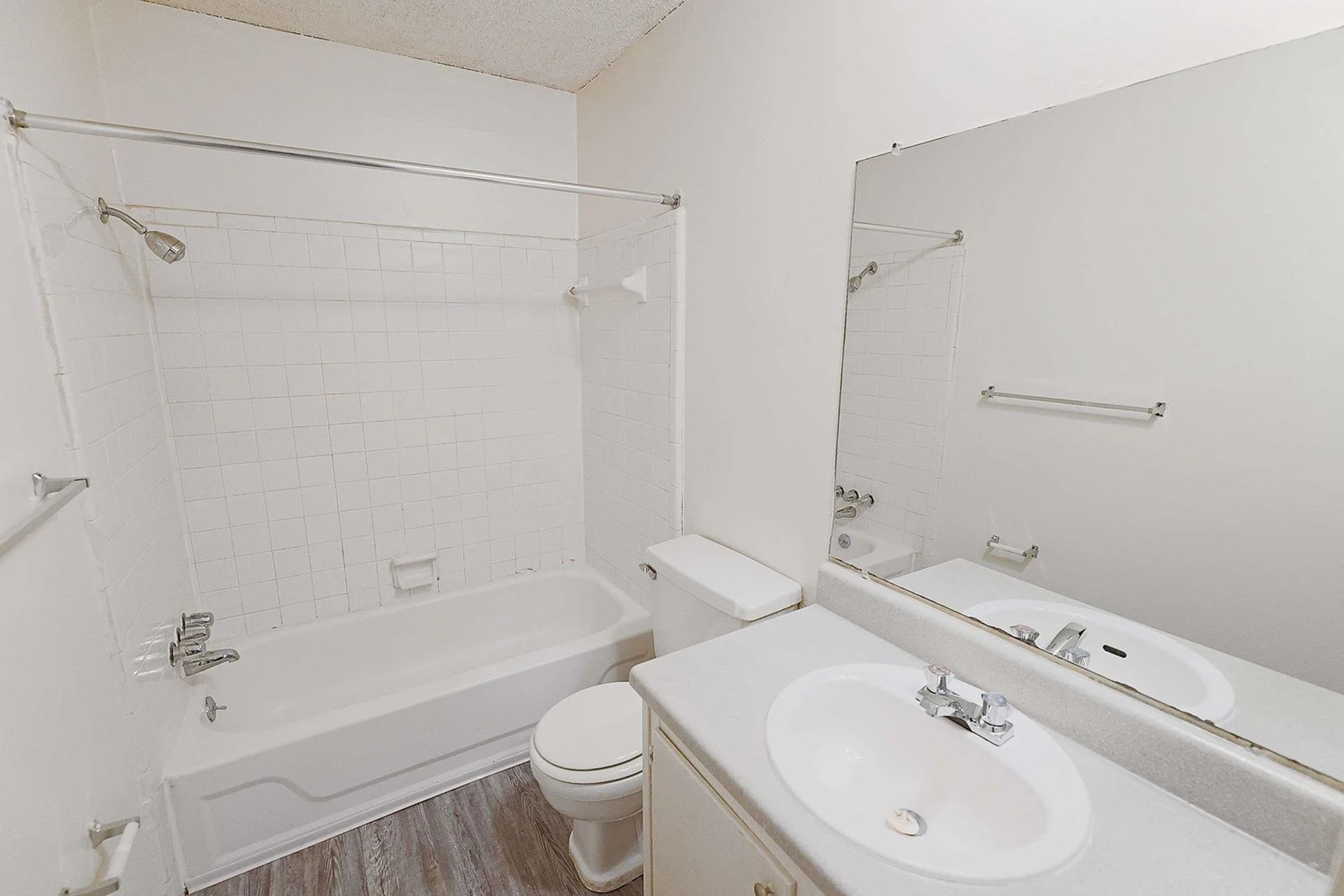 A bathroom with a sink , toilet , bathtub and mirror.