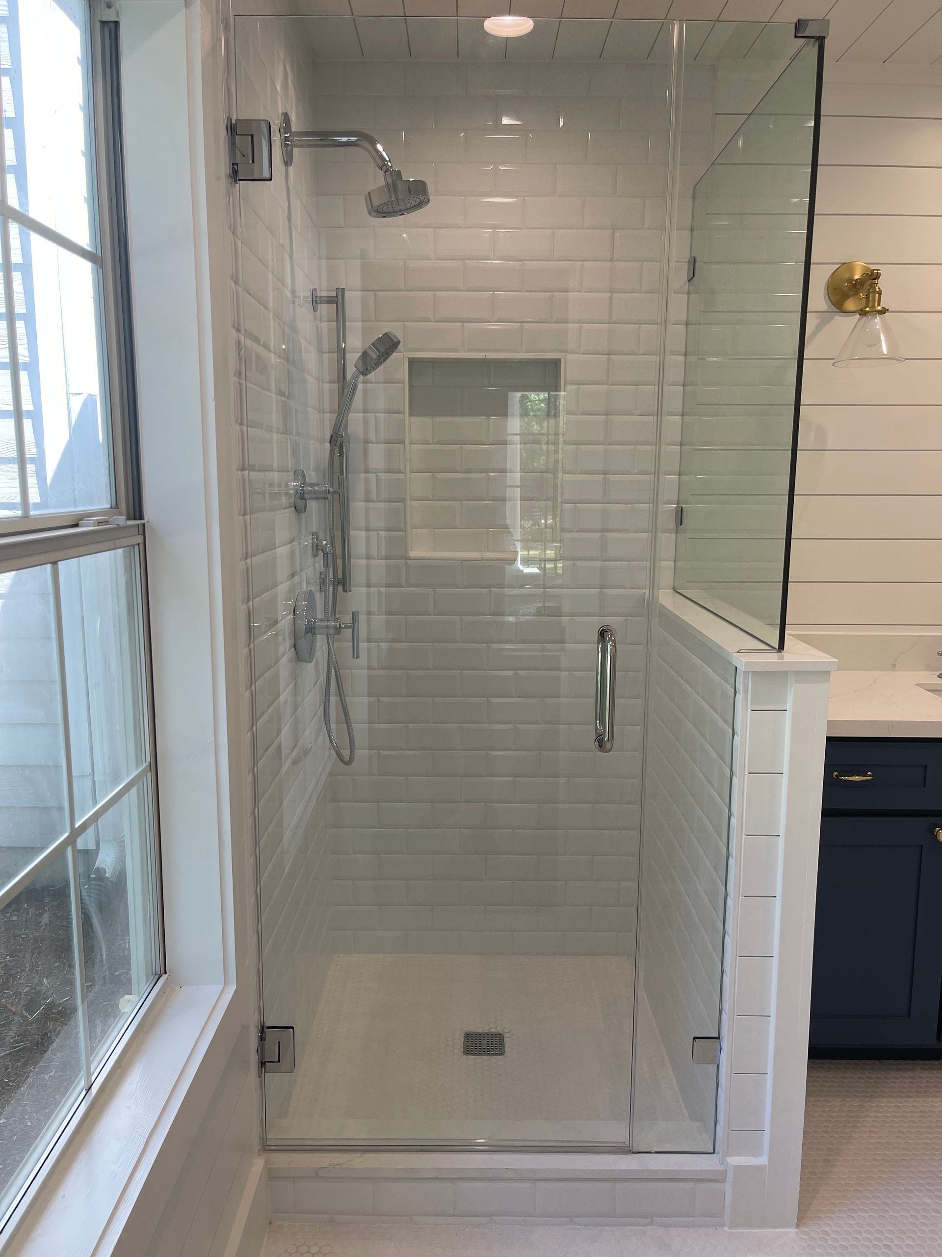 A bathroom with a subway tile walk in shower