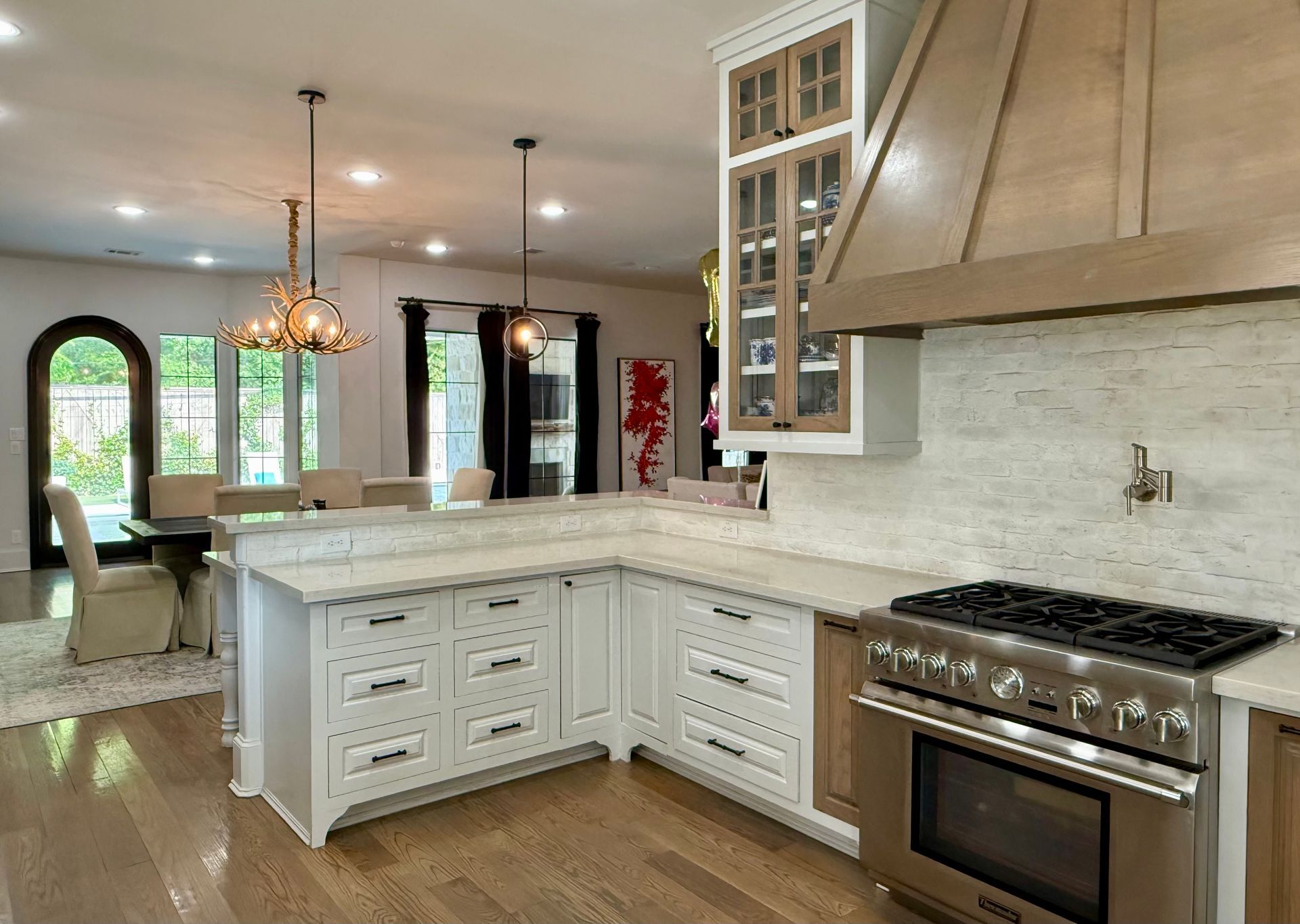 A kitchen with white cabinets , stainless steel appliances , and a large island.