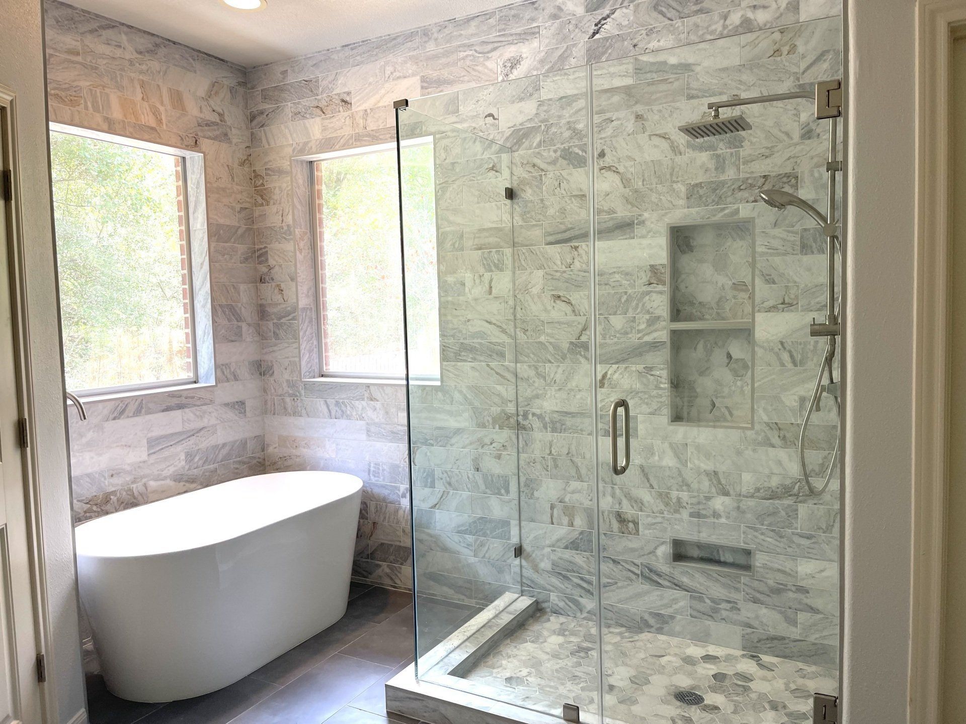 A bathroom with a free-standing bathtub and a glass walk in shower.