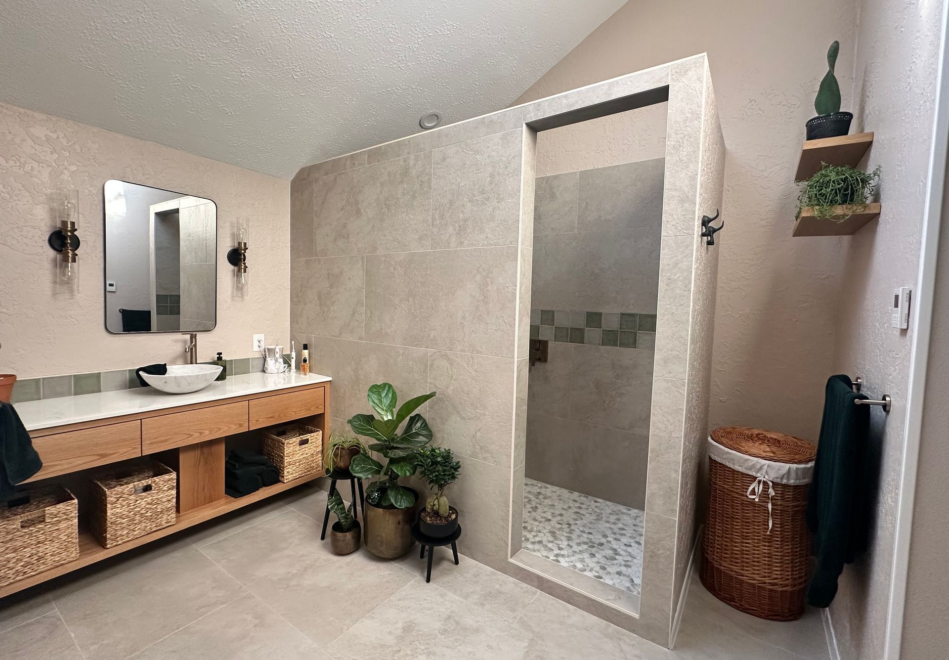 A modern bathroom with a walk in shower and wood vanity with sink