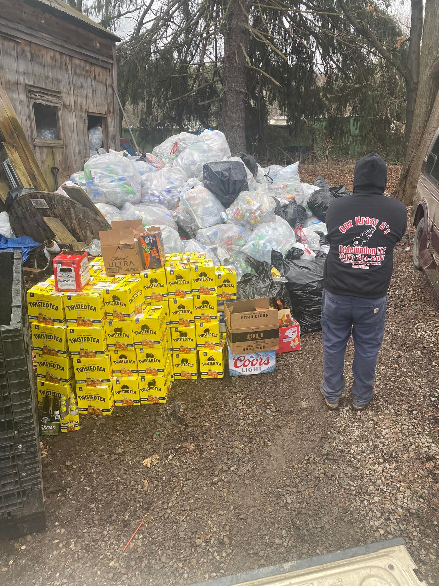 A man is standing in front of a pile of trash.