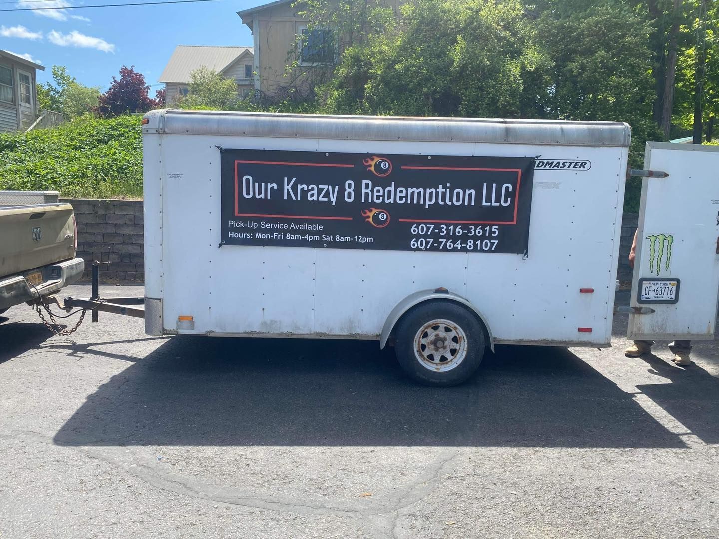 A white trailer with a black banner that says our krazy 8 redemption llc