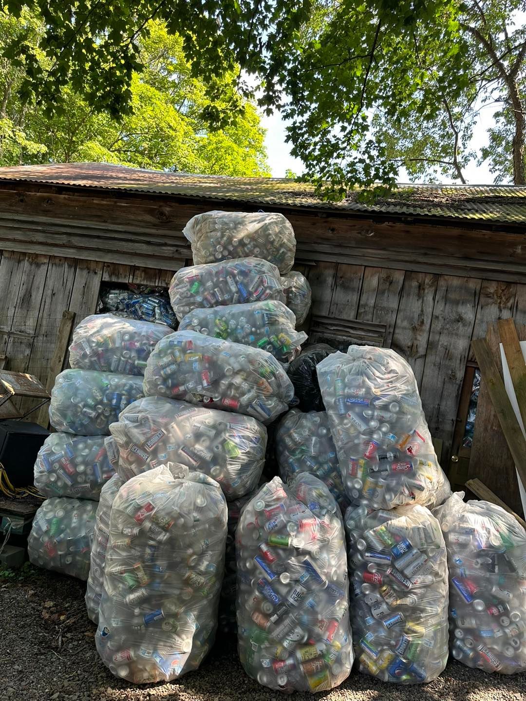 A bunch of bags filled with aluminum cans are stacked on top of each other.