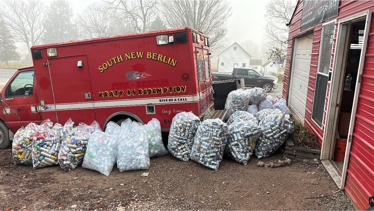 A red ambulance is filled with bags of bottle caps.