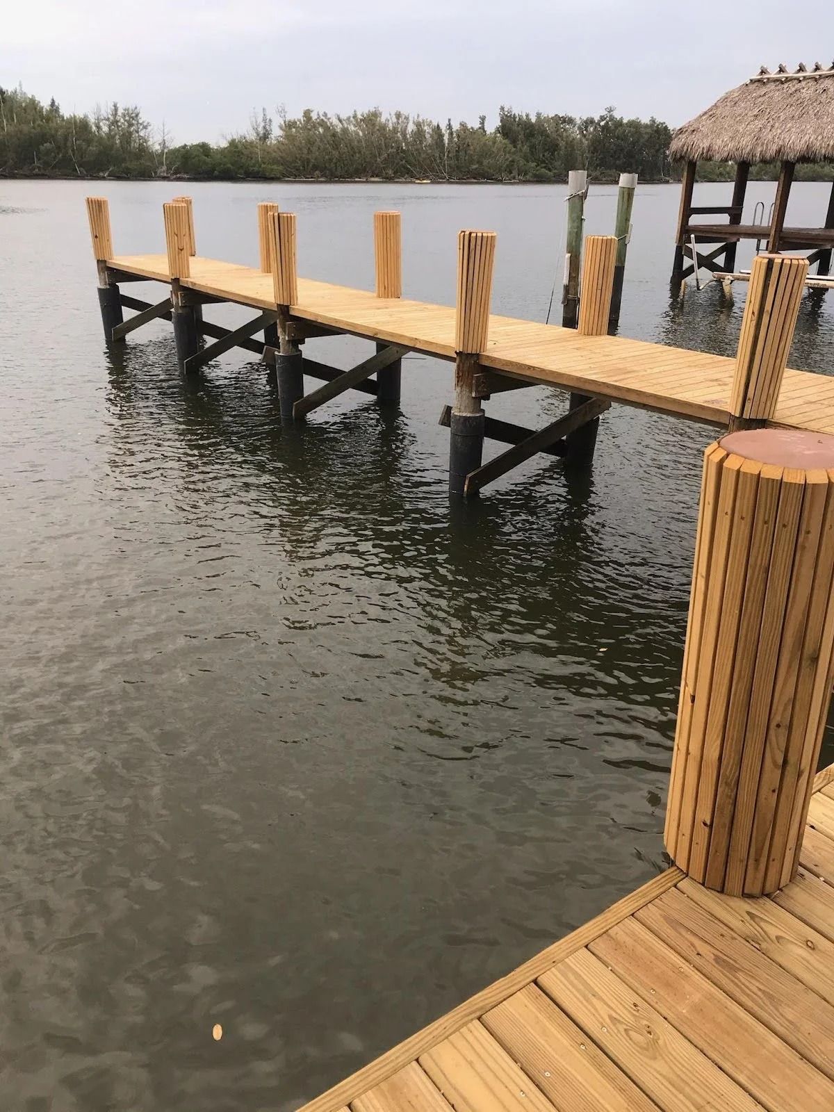 A wooden dock is in the middle of a body of water.