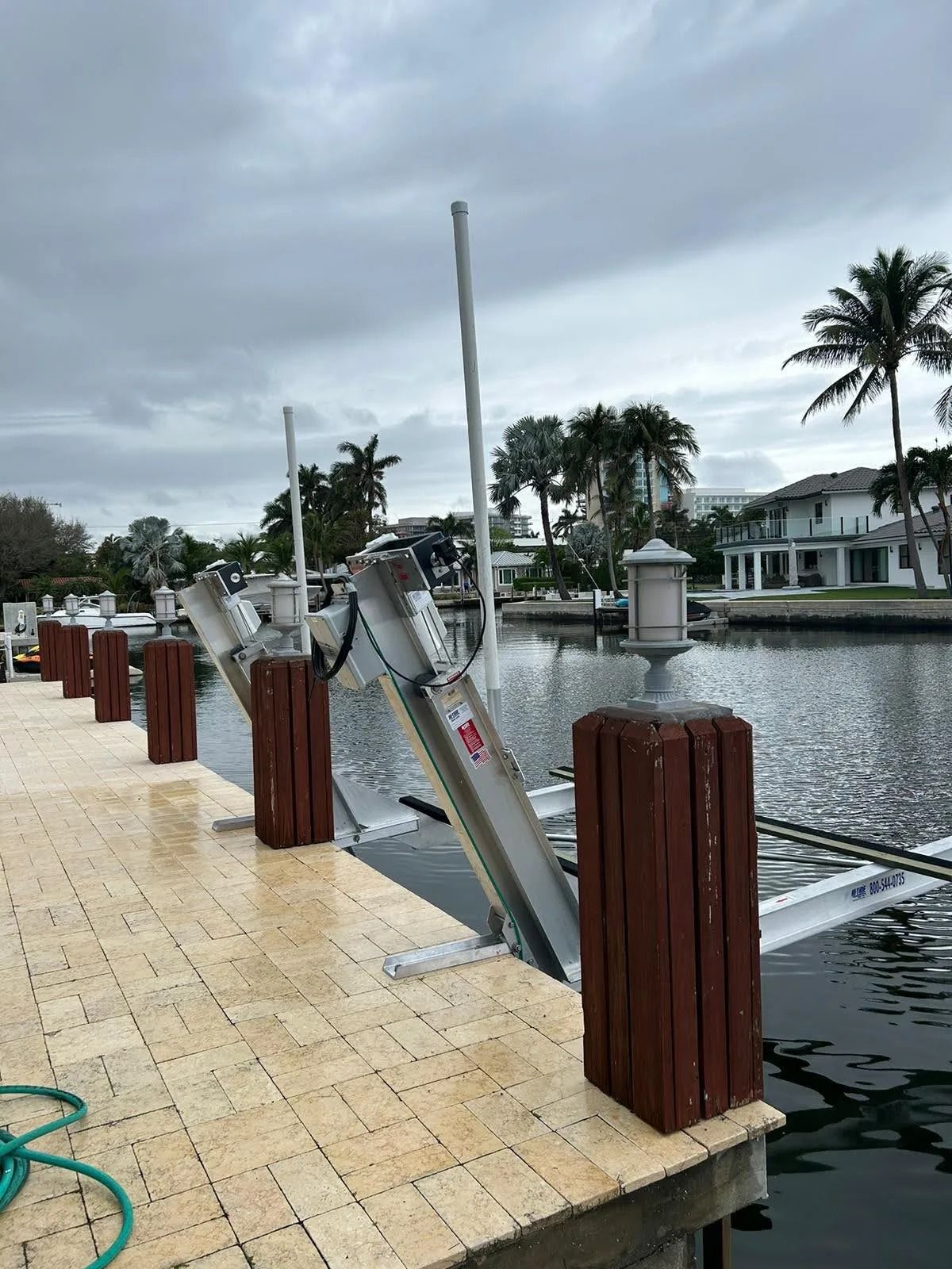 A dock with a hose attached to it next to a body of water.