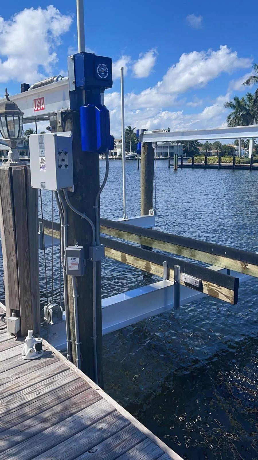A dock with a boat lift attached to it next to a body of water.