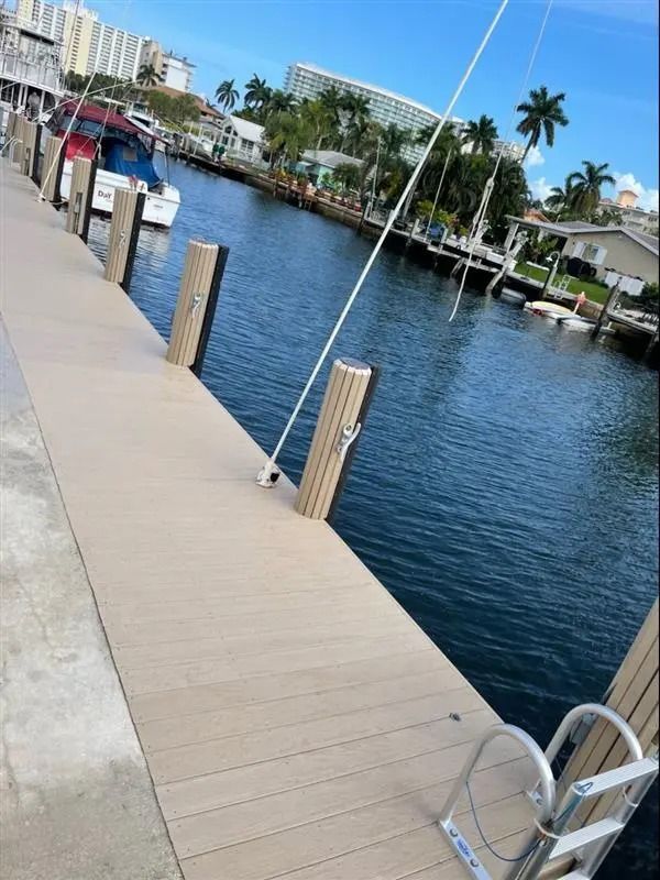 A boat is docked at a dock next to a body of water.