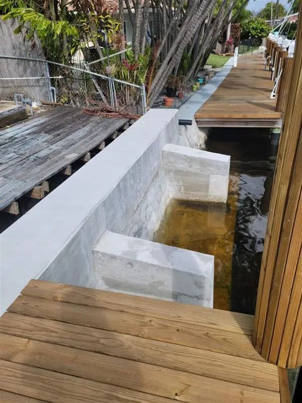 A wooden bench is sitting next to a body of water.