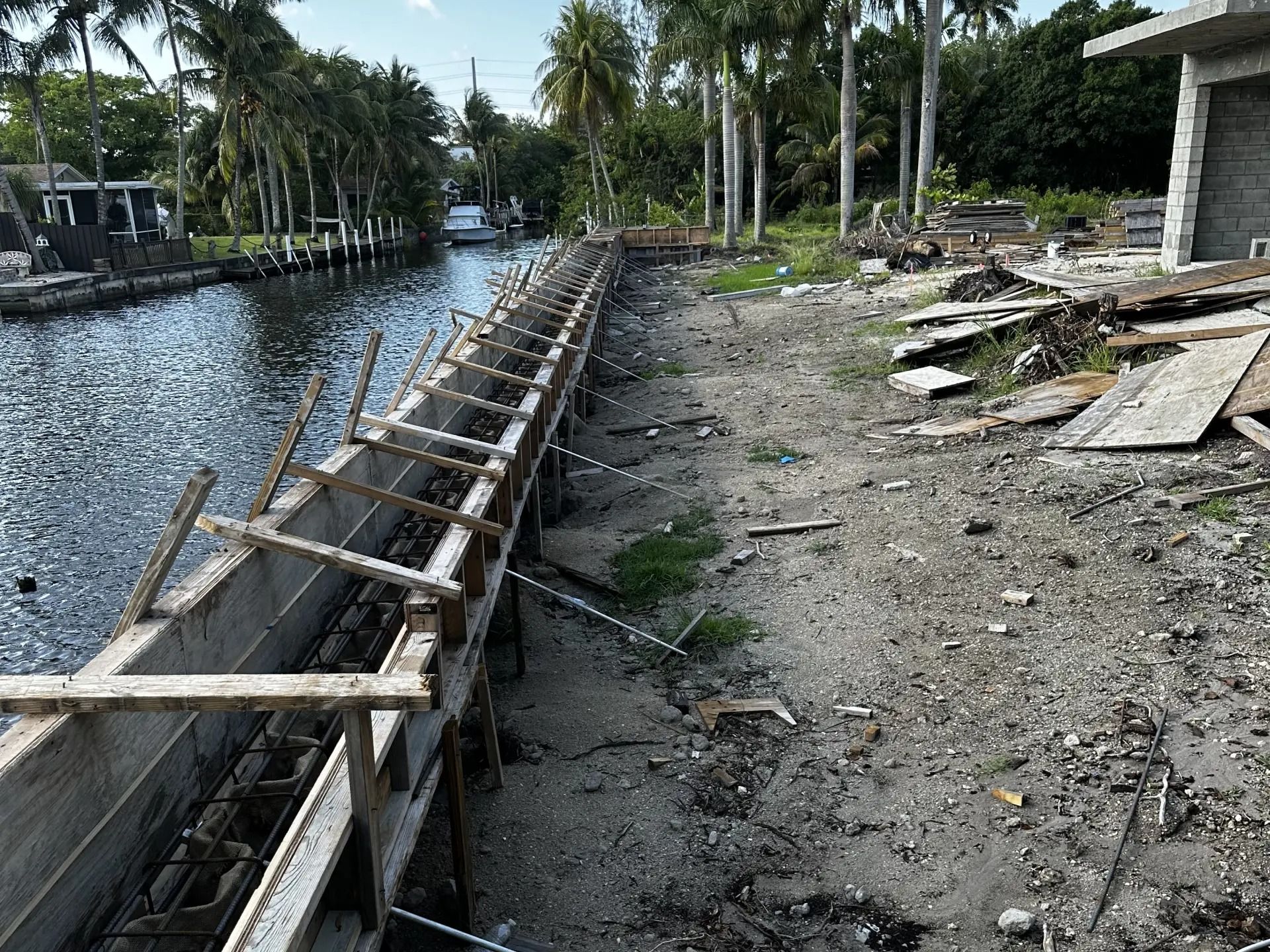 A concrete wall is being built next to a body of water.